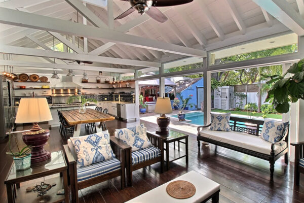 A picture of a spacious home in Key West with open ceiling space and sliding pocket windows opening to the pool.
